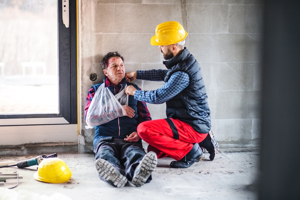 colleague giving first aid injured worker